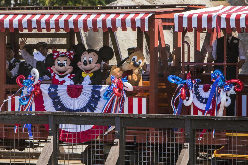 DISNEYLAND RAILROAD RETURNS -- Streamers and fireworks flew overhead as the Disneyland Railroad made its highly anticipated return trip around Disneyland park with Mickey and all his pals on Friday, June 28. The iconic railroad, reopening July 29, now features a path along the north end of the river where it crosses a new trestle and hugs the riverbank which now features five majestic waterfalls. (Joshua Sudock/Disneyland Resort)